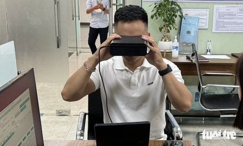 Làm căn cước mới: Lấy mống mắt, ADN, thu giọng nói ra sao?- Ảnh 4. Người dân thực hiện thu nhận thông tin mống mắt rất nhanh chóng - Ảnh: THÀNH CHUNG