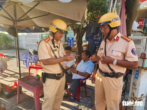 Cảnh sát giao thông TP.HCM tạm giữ giấy phép lái xe trên VNeID như thế nào?- Ảnh 4. Cảnh sát giao thông quận Bình Thạnh sẽ kiểm tra giấy phép lái xe trên VNeID, nếu trường hợp vi phạm có tạm giữ giấy phép lái xe thì cảnh sát giao thông sẽ lập biên bản tạm giữ giấy phép này trên môi trường điện tử - Ảnh: MINH HÒA