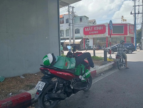 Những giấc ngủ trưa vội vã bên đường- Ảnh 4. Một tài xế xe ôm công nghệ ngủ say ngay dưới dạ cầu vượt ngã tư 550, TP Thuận An, Bình Dương - Ảnh: ĐỊNH DƯƠNG