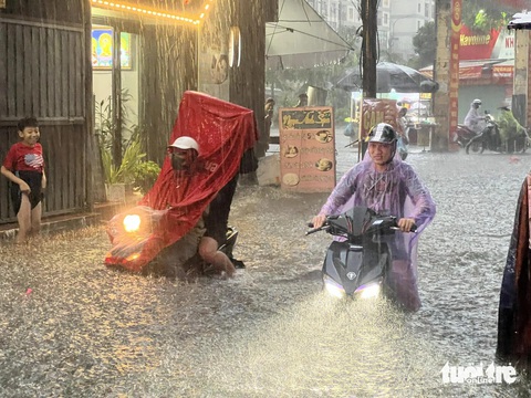 Mưa lớn, nhiều đường phố Hà Nội ngập lút bánh xe- Ảnh 3. Nước ngập sâu hết cả bánh xe - Ảnh: PHẠM TUẤN