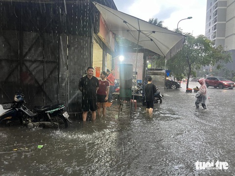 Mưa lớn, nhiều đường phố Hà Nội ngập lút bánh xe- Ảnh 5. Người dân bì bõm lội nước - Ảnh: PHẠM TUẤN