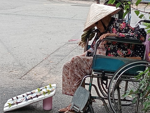 Những giấc ngủ trưa vội vã bên đường- Ảnh 1. Bà cụ bán vé số ngủ ngon lành trên chiếc xe lăn - Ảnh: ĐỊNH DƯƠNG