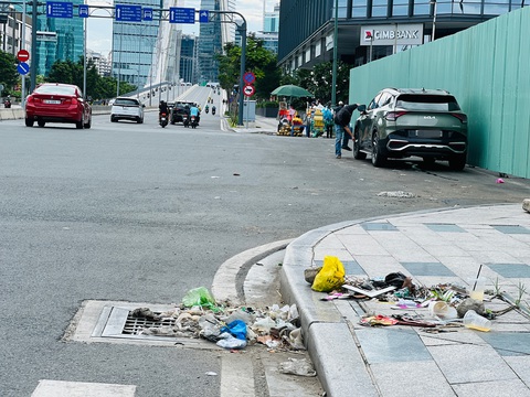 Rác thải đầy đường dẫn lên cầu Ba Son, sao không ai dọn dẹp?- Ảnh 2. Nước mưa cuốn rác thải tụ quanh miệng cống thoát nước đường R12, lâu ngày không dọn - Ảnh: XUÂN ĐOÀN