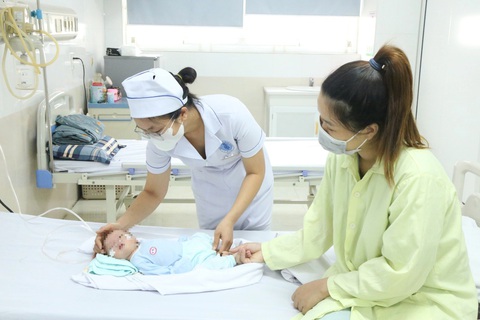 Nữ điều dưỡng cứu sống bé 7 ngày tuổi ngừng thở vì sặc sữa trên đường về nhà- Ảnh 2. Nữ điều dưỡng Nguyễn Thị Thảo (áo trắng) tiếp tục theo dõi, chăm sóc cháu bé tại Bệnh viện Trẻ em Hải Phòng - Ảnh: Bệnh viện cung cấp