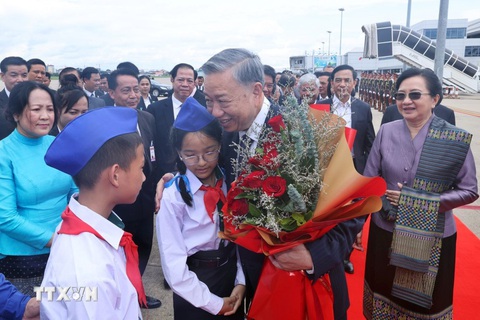 Chủ tịch nước Tô Lâm đọc Kiều khi thăm trường song ngữ, trao quà cho người Việt ở Lào- Ảnh 8. Hai thiếu nhi Lào tặng hoa cho Chủ tịch nước Tô Lâm - Ảnh: TTXVN