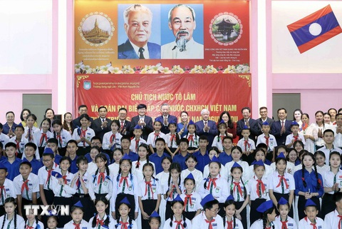 Chủ tịch nước Tô Lâm đọc Kiều khi thăm trường song ngữ, trao quà cho người Việt ở Lào- Ảnh 3. Chủ tịch nước Tô Lâm chụp ảnh cùng các cháu học sinh và thầy cô Trường Nguyễn Du - Ảnh: TTXVN
