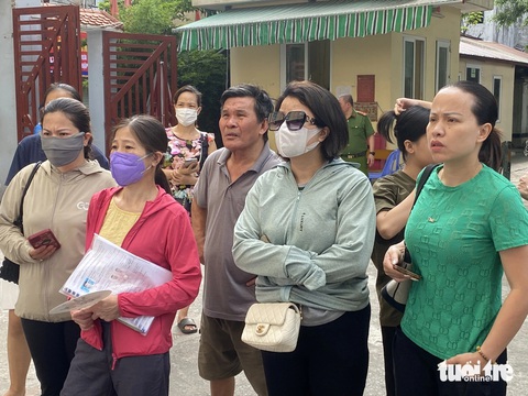 Học sinh giỏi 4 năm vẫn trượt lớp 10 công lập Hà Nội, phụ huynh mang hồ sơ đi nộp tràn tuyến- Ảnh 1. Phụ huynh cầm trên tay tập hồ sơ tuyển sinh vào lớp 10 trước cổng Trường THPT Đoàn Kết - Hai Bà Trưng, ghi nhận sáng 13-7 - Ảnh: NGUYÊN BẢO