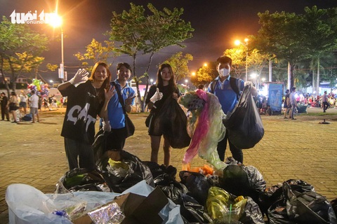 Tích cực dọn rác, giới trẻ Đà Nẵng để lại hình ảnh đẹp sau lễ hội pháo hoa- Ảnh 1. Thành viên của CLB Chiến binh Poly Đà Nẵng cùng du khách chung tay thu gom rác sau chung kết pháo hoa quốc tế 2024 - Ảnh: THANH NGUYÊN