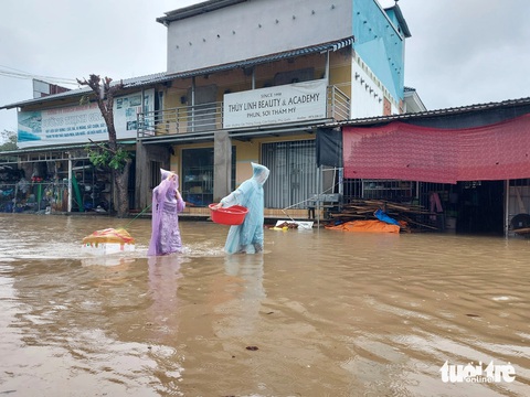 Mưa 2 ngày gây ngập cục bộ, người dân Phú Quốc đi lại khó khăn- Ảnh 2. Để rau củ trong thùng xốp, người dân kéo về nhà do nước ngập - Ảnh: CHÍ CÔNG