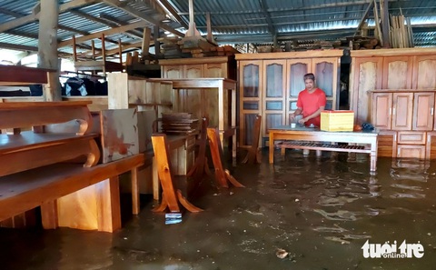 Mưa 2 ngày gây ngập cục bộ, người dân Phú Quốc đi lại khó khăn- Ảnh 3. Nước tràn vào nhà, người dân không kịp kê đồ đạc, tủ bàn lên cao - Ảnh: CHÍ CÔNG