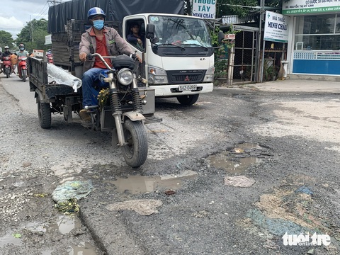 Người dân chật vật với những tuyến đường xuống cấp, chi chít Các phương tiện đi trên đường Phạm Văn Sáng (xã Vĩnh Lộc A, huyện Bình Chánh) đều phải giữ tốc độ ở mức tối thiểu để tránh gây tai nạn giao thông - Ảnh: KSOR QUÝ