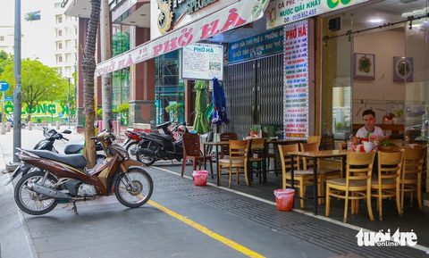 Vỉa hè trung tâm TP.HCM đổi thay ra sao sau 2 tháng thực hiện đề án mới?- Ảnh 7. Trong ảnh là một quán phở trên đường Hải Triều xếp bàn ghế ngăn nắp, thực khách đến cũng được hướng dẫn để xe phía ngoài vạch vàng để dành chỗ cho người đi bộ chính giữa - Ảnh: CHÂU TUẤN