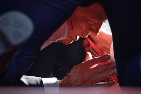 Ông Trump được các nhân viên Mật vụ che chắn hoàn toàn sau khi có tiếng súng nổ - Ảnh: GETTY IMAGES Ông Trump được các nhân viên mật vụ che chắn hoàn toàn sau khi có tiếng súng nổ - Ảnh: GETTY IMAGES