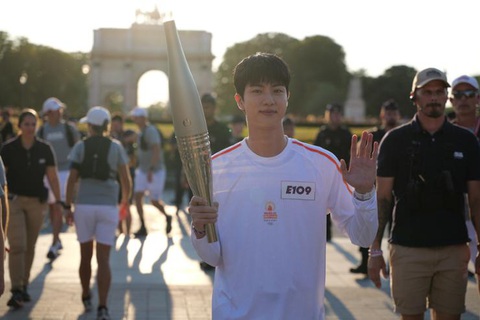 Jin cầm ngọn đuốc Olympic Paris, dẫn đầu đoàn diễu hành ngày 15-7 - Ảnh: Yonhap Jin vẫy tay chào người hâm mộ - Ảnh: Yonhap