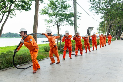 6 tháng đầu năm, sức tiêu thụ điện toàn miền Trung tăng trưởng tốt- Ảnh 1. Công nhân Điện lực Thừa Thiên Huế kéo dây điện chuẩn bị cho lễ hội Festival 2024 - Ảnh: EVNCPC cung cấp