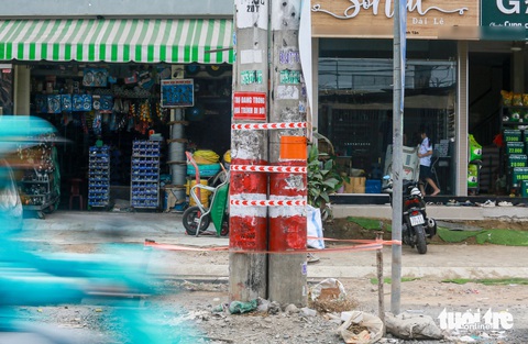 Khởi công hơn 15 tháng, cột điện vẫn chình ình dọc dự án đường Tân Kỳ Tân Quý?- Ảnh 1. Các bảng ghi trụ đang trong quá trình di dời được gắn trên trụ điện ở đường Tân Kỳ Tân Quý (Bình Tân) - Ảnh: CHÂU TUẤN