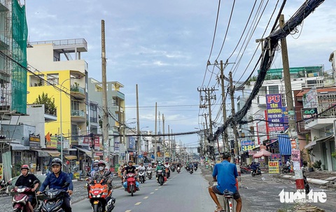 Khởi công hơn 15 tháng, cột điện vẫn chình ình dọc dự án đường Tân Kỳ Tân Quý?- Ảnh 2. Dây điện chằng chịt ở dự án mở rộng đường Tân Kỳ Tân Quý - Ảnh: CHÂU TUẤN