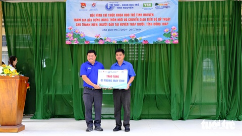 Thành ủy, Thành Đoàn TP.HCM thăm chiến sĩ Mùa hè xanh ở Đồng Tháp- Ảnh 3. Ông Huỳnh Cách Mạng - phó trưởng ban thường trực Ban Tổ chức Thành ủy TP.HCM (bên trái) - trao tặng bảng tượng trưng một phòng máy tính cho Huyện đoàn Tháp Mười - Ảnh: ĐẶNG TUYẾT