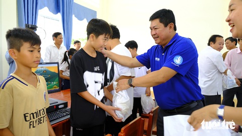 Thành ủy, Thành Đoàn TP.HCM thăm chiến sĩ Mùa hè xanh ở Đồng Tháp- Ảnh 4. Ông Huỳnh Cách Mạng - phó trưởng ban thường trực Ban Tổ chức Thành ủy TP.HCM - trao quà cho học sinh - Ảnh: ĐẶNG TUYẾT