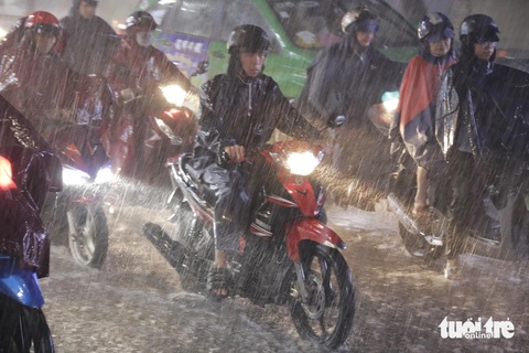 Mưa lớn giờ tan tầm ở TP.HCM, lại điệp khúc 'ngập, kẹt xe'- Ảnh 5. Mưa nặng hạt trút xuống bất ngờ khiến việc đi lại của người dân gặp phải khó khăn - Ảnh: TIẾN QUỐC