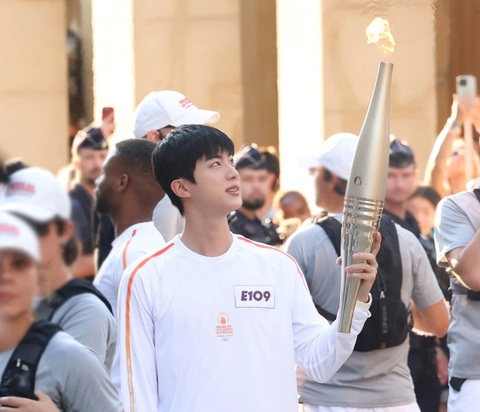 Jin cầm ngọn đuốc Olympic Paris, dẫn đầu đoàn diễu hành ngày 15-7 - Ảnh: Yonhap Jin cầm ngọn đuốc Olympic Paris, dẫn đầu đoàn diễu hành ngày 15-7 - Ảnh: Yonhap