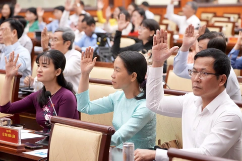 TP.HCM: Chính thức miễn, giảm học phí cho mọi cấp, điều chỉnh một số khoản thu- Ảnh 1. Các đại biểu biểu quyết thông qua dự thảo nghị quyết - Ảnh: HỮU HẠNH