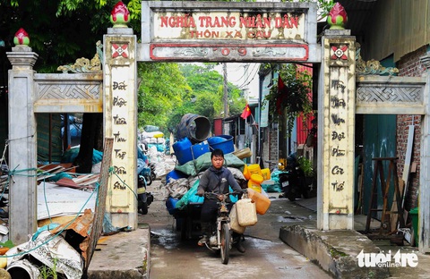 Mưu sinh ở 'thủ phủ' phế liệu ngoại thành Hà Nội- Ảnh 1. Một người đàn ông đang chở phế liệu từ nghĩa trang thôn Xà Cầu ra ngoài đường trục chính. Tại thôn Xà Cầu hiện có 170-180 hộ gia đình trên tổng số 800 hộ làm nghề thu mua, sơ chế rác thải nhựa - Ảnh: THÚY TRANG