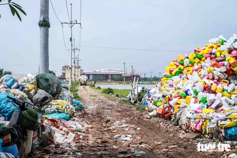 Mưu sinh ở 'thủ phủ' phế liệu ngoại thành Hà Nội- Ảnh 5. Trước đây, Xà Cầu vốn là nơi sản xuất tăm tre và hương đen. Thế nhưng do không cạnh tranh được với các nơi khác, một số hộ dân đã chuyển sang thu gom, tái chế rác. Trong ảnh: Phế liệu ngổn ngang chất đống trên đường làng - Ảnh: HOA NGUYỄN