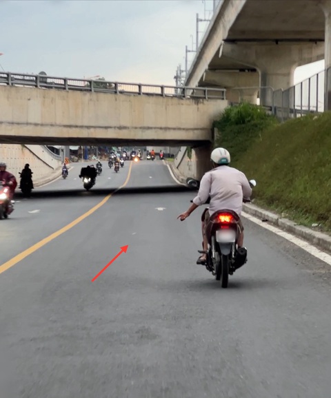 Vừa lái xe vừa phì phèo thuốc lá, mặc kệ người xung quanh lãnh 'đạn'- Ảnh 6. Hút thuốc xong, người đàn ông vứt đầu lọc thuốc giữa đường - Ảnh: XUÂN ĐOÀN