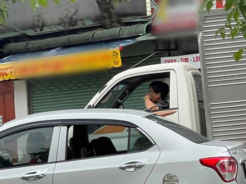 Vừa lái xe vừa phì phèo thuốc lá, mặc kệ người xung quanh lãnh 'đạn'- Ảnh 4. Tài xế xe tải một tay giữ vô lăng, một tay hút thuốc - Ảnh: XUÂN ĐOÀN
