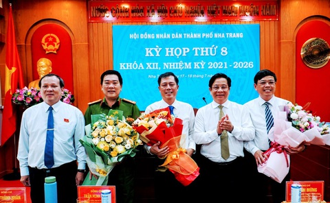 UBND TP Nha Trang có chủ tịch mới- Ảnh 1. Lãnh đạo TP Nha Trang tặng hoa, chúc mừng các ông Nguyễn Sỹ Khánh (ngoài cùng bên phải), ông Trần Minh Chiến (giữa) và trưởng Công an TP Nha Trang (thứ 2, từ trái qua) - Ảnh: LÊ XUÂN