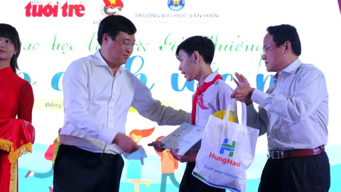Chắp cánh ước mơ vươn tới tương lai cho học sinh miền Tây- Ảnh 1. Ông Lê Quốc Phong - bí thư Tỉnh ủy Đồng Tháp (bìa trái) và nhà báo Nguyễn Hoàng Nguyên - phó tổng biên tập báo Tuổi Trẻ trao học bổng cho các em học sinh - Ảnh: ĐẶNG TUYẾT
