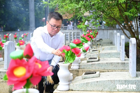 Hội Nhà báo Việt Nam tổ chức 'Thắp sáng ngọn lửa tri ân'- Ảnh 1. Ông Lê Quốc Minh - tổng biên tập báo Nhân Dân, phó trưởng Ban Tuyên giáo Trung ương, chủ tịch Hội Nhà báo Việt Nam - thắp hương phần mộ liệt sĩ tại nghĩa trang quốc tế Việt - Lào, huyện Anh Sơn, Nghệ An - Ảnh: CƯỜNG NGUYỄN