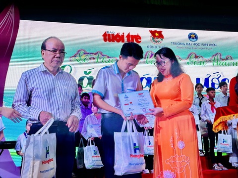 Chắp cánh ước mơ vươn tới tương lai cho học sinh miền Tây- Ảnh 3. Bà Nguyễn Thị Diễm Tuyết - giám đốc điều hành Trường đại học Văn Hiến và ông Trần Văn Thiện - giám đốc danh dự Quỹ Trái tim Hùng Hậu - trao học bổng cho các em học sinh - Ảnh: ĐẶNG TUYẾT