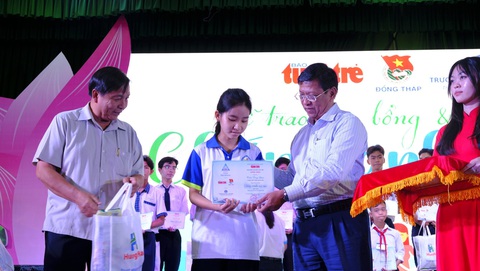 Chắp cánh ước mơ vươn tới tương lai cho học sinh miền Tây- Ảnh 5. Ông Lê Thành Công - trưởng Ban dân vận Tỉnh ủy Đồng Tháp (bìa trái) và ông Trần Thanh Hương - phó chủ tịch thường trực Đại học Văn Hiến trao học bổng cho các em học sinh khu vực miền Tây - Ảnh: ĐẶNG TUYẾT