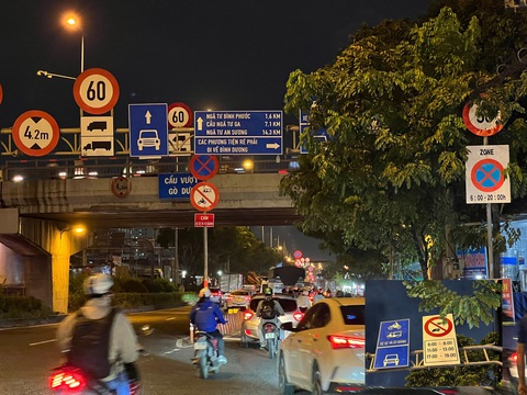 Biển báo giao thông Biển cấm xe khách trên 25 chỗ, xe tải trên 2,5 tấn đi vào làn hỗn hợp (trong ba khung giờ cao điểm) trên quốc lộ 1, đoạn cầu vượt Gò Dưa bị nhánh cây che toàn bộ - Ảnh: XUÂN ĐOÀN