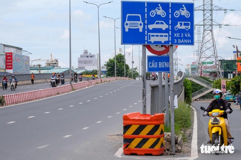 Cầu Bưng thông xe 2 năm vẫn vướng mặt bằng đường dân sinh- Ảnh 1. Cầu Bưng bắc qua kênh Tham Lương (nối hai quận Tân Phú và Bình Tân trên trục đường Lê Trọng Tấn) thông xe từ năm 2022, nhưng đến nay một số hạng mục chiếu sáng, đường dân sinh bên phải cầu chưa hoạt động phục vụ người dân - Ảnh: PHƯƠNG NHI