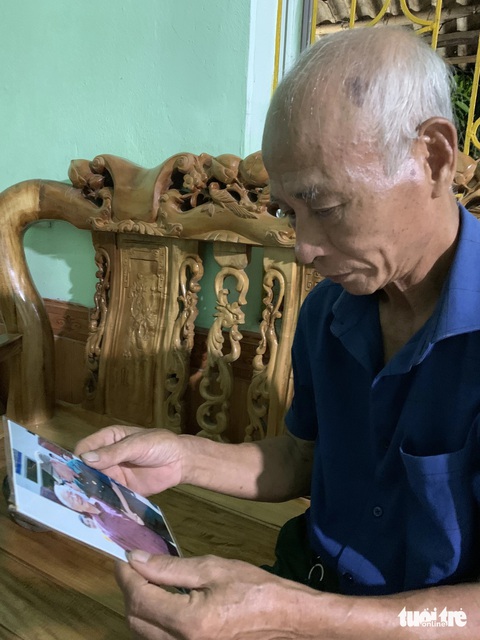 Nhớ lời Tổng bí thư, Pom Lót đoàn kết một lòng- Ảnh 1. Cựu chiến binh Nguyễn Văn Oai nâng niu tấm ảnh được chụp cùng với Tổng bí thư Nguyễn Phú Trọng trong lần về thăm xã Pom Lót vào năm 2016 - Ảnh: LÊ NIÊN