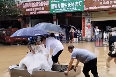 Chú rể và bố vợ đẩy cô dâu ngồi thuyền đến đám cưới- Ảnh 1. Cô dâu được bố của mình và chú rể đưa đến đám cưới nhờ con thuyền tự chế.