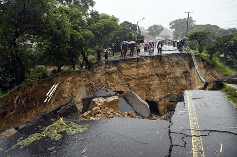 A general view of a collapsed road caused by flooding waters due to heavy rains caused by Tropical Cyclone Freddy in Blantyre, Malawi, on Monday. Amos Gumulira/AFP/Getty Images Mưa lũ do bão Freddy gây sạt lở đường lớn ở Blantyre, Malawi - Ảnh: AFP/Getty Images