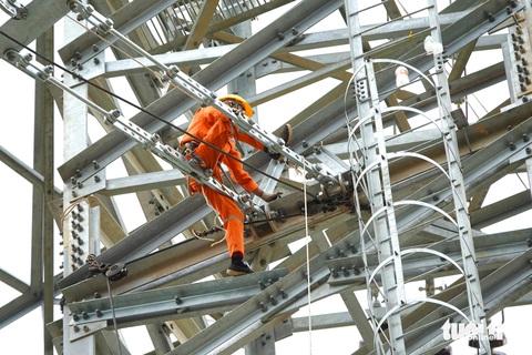 Những công nhân vắt vẻo trên cột thép đường dây 500kV mạch 3- Ảnh 7. Mỗi ngày tốp công nhân của anh Lực làm việc từ 6h sáng đến hơn 10h, buổi chiều từ 14h đến khoảng 18h. Nhóm công nhân được chia làm 2 tổ, tổ ở mặt đất thực hiện công việc tời dây cáp, còn tổ làm việc trên cột thực hiện việc căng dây, đi khung - Ảnh: LÊ MINH