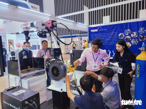 Khám phá công nghệ mới nhất ngành cơ khí tại MTA Vietnam 2024- Ảnh 1. Khách tham quan tìm hiểu một chiếc tay robot tại MTA Vietnam 2024 - Ảnh: NHẬT XUÂN