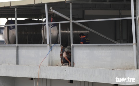 Nhà sai phép thành chung cư, nhà trọ phường An Khánh: Đang tháo dỡ phần vi phạm- Ảnh 4. Các công nhân đang tháo phần tôn, khung sắt, tường... sai phạm trên tầng thượng căn nhà 9/1 đường số 4 - Ảnh: MINH HÒA
