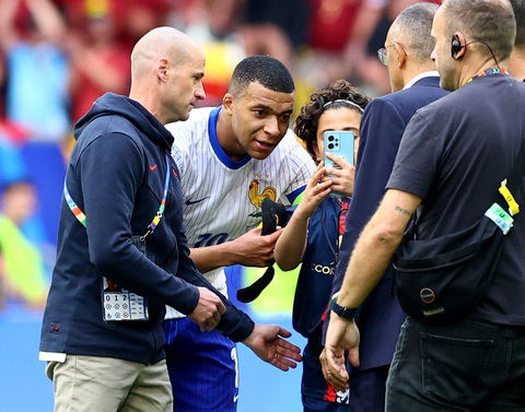 Tuyển Pháp vẫn may khi Mbappe đeo mặt nạ- Ảnh 3. Mbappe vui vẻ chụp hình cùng cậu bé chạy xuống sân sau trận đấu với Bỉ - Ảnh: REUTERS