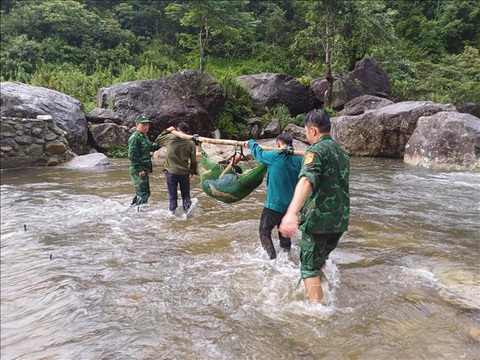 Cứu sống người đàn ông bị rơi xuống vực trong rừng đã 4 ngày- Ảnh 1. Bộ đội biên phòng và người dân trong vùng đã dùng võng khiêng nạn nhân đi bộ 4 giờ về bản và đưa đi cấp cứu - Ảnh: TTXVN