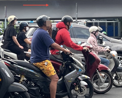 Indonesia: Hút thuốc khi đang lái xe có thể bị tù 3 tháng- Ảnh 1. Hút thuốc rồi nhả khói ra trong lúc nhiều người đang chờ đèn đỏ trên đường phố - Ảnh: XUÂN ĐOÀN