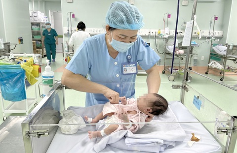Bà Phan Thị Mỹ đang chăm sóc bệnh nhi tại khoa sơ sinh Bệnh viện Nhi đồng 1 - Ảnh: THÙY DƯƠNG Những bảo mẫu trong bệnh viện- Ảnh 1.
