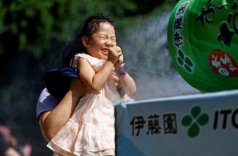 Bé gái thể hiện sự sảng khoái trước máy phun sương làm mát ở đền Sensoji, Tokyo hôm 22-7, trong bối cảnh cảnh báo sốc nhiệt đã được ban hành ở 39 trên 47 tỉnh thành của Nhật Bản. Ảnh: Reuters Tin tức thế giới 23-7: Tin vui tới tấp cho bà Harris; Ukraine