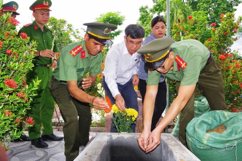 Đại diện các đơn vị rải hoa và đất xuống phần mộ các liệt sĩ - Ảnh: TRẦN HOÀI Tìm thấy 3 bộ hài cốt liệt sĩ ở trạm xá dã chiến xưa, nay là khu du lịch- Ảnh 2.