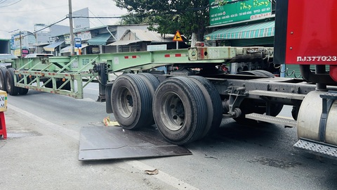 Tấm thép chỏng chơ trên đường, dân sợ té ngã lọt gầm container- Ảnh 3. Mỗi lần bánh xe cán lên là tấm thép kêu rầm rầm, trượt dần ra khỏi hố ga - Ảnh: XUÂN ĐOÀN